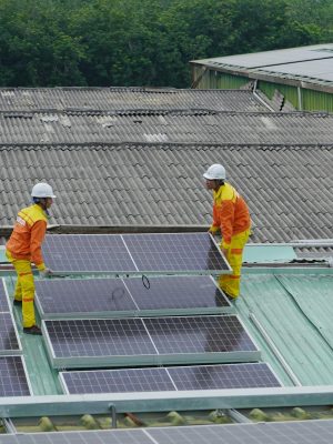 Workers installing solar panels on a roof for sustainable energy solutions.